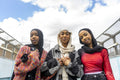 Portrait of smiling young women wearing hijabs holding hands
