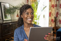 Smiling woman using digital tablet at home