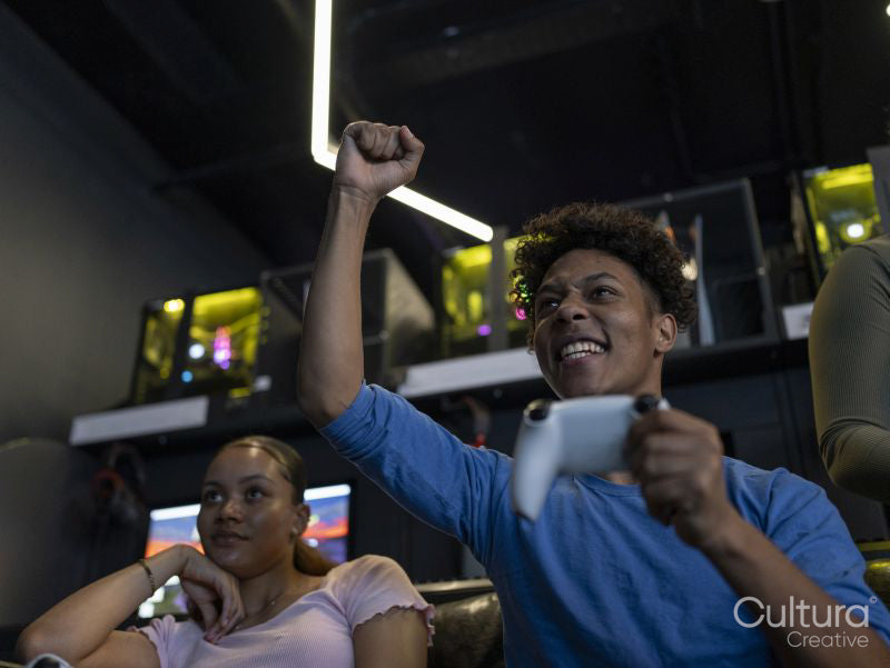 Excited man playing video games with friend in gaming club