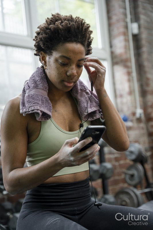 Woman using phone during training on gym
