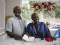 Close-up of mature couple holding passport at hotel front desk