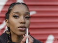 Young woman applying make-up, portrait