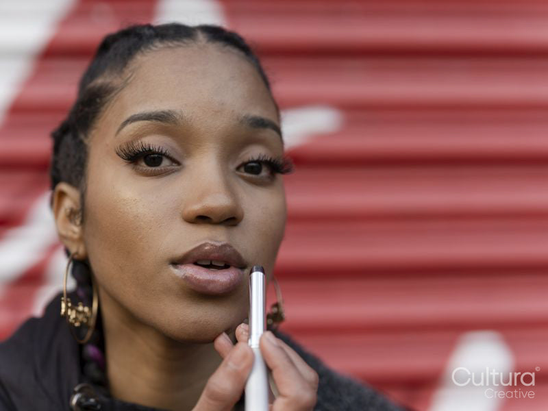 Young woman applying make-up, portrait