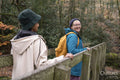Smiling female hikers on bridge in forest