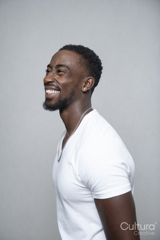 Portrait of smiling man wearing white t-shirt and necklace