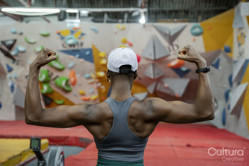Rear view of woman flexing muscles at gym