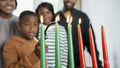 Family with children lighting kinara candles