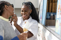 Young female friends buying ice cream in ice cream truck