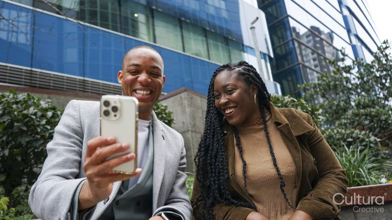 Business man and woman taking selfie outside office building