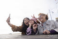 Grandmother, mother and daughter taking selfie with smart phone