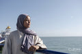 Portrait of thoughtful Muslim woman looking at sea on sunny day