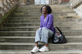 Smiling woman sitting on steps in city