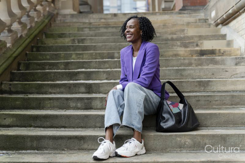 Smiling woman sitting on steps in city