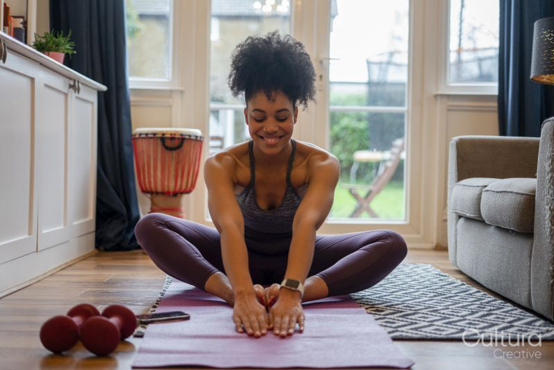 Young woman stretching at home