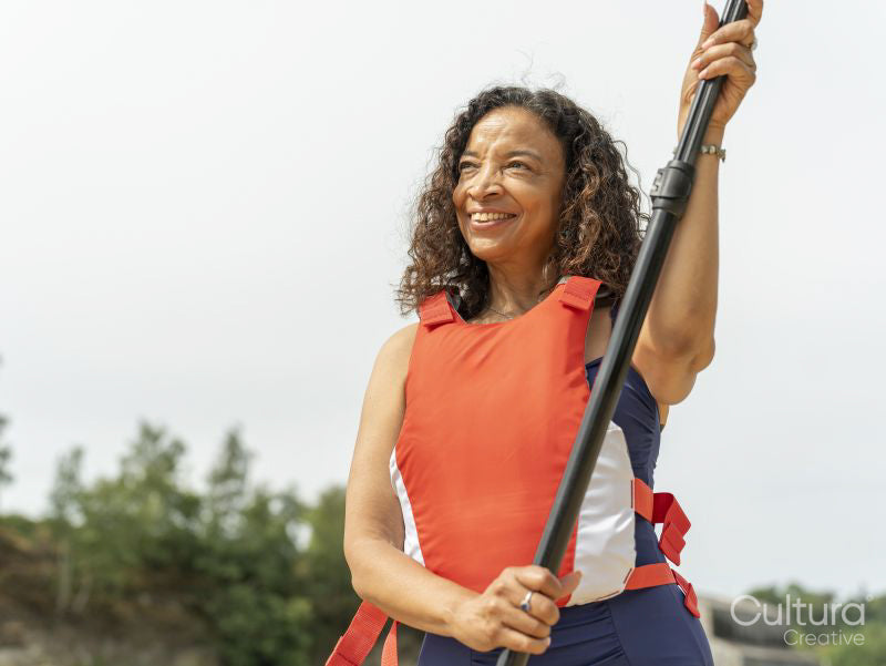 Portrait of smiling woman standing with oar