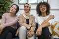 Portrait of smiling women sitting on sofa