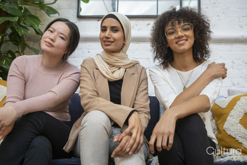 Portrait of smiling women sitting on sofa