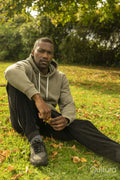 Portrait of man sitting on lawn in park in autumn