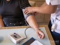 Nurse measuring blood pressure of mature woman