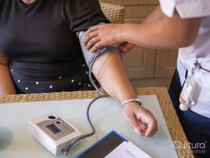 Nurse measuring blood pressure of mature woman