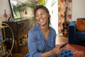 Smiling woman using smart phone at home