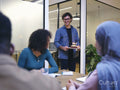 Smiling man with birthday cake entering conference room