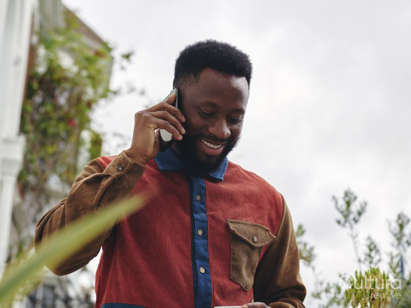 Smiling man talking on smart phone outdoors