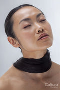 Studio portrait of woman with hair wrapped around neck