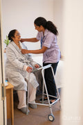 Nurse helping senior lady in her room at nursing home