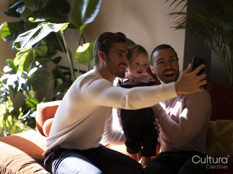 couple taking selfie with baby daughter in living room