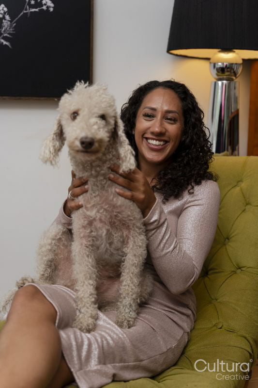 Woman sitting with bedlington terrier on her lap
