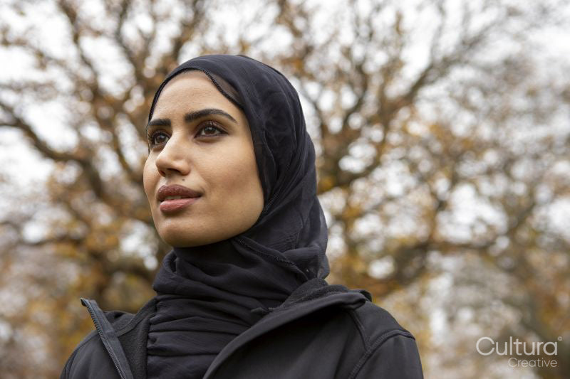 Portrait of woman in black sports clothing and hijab in park