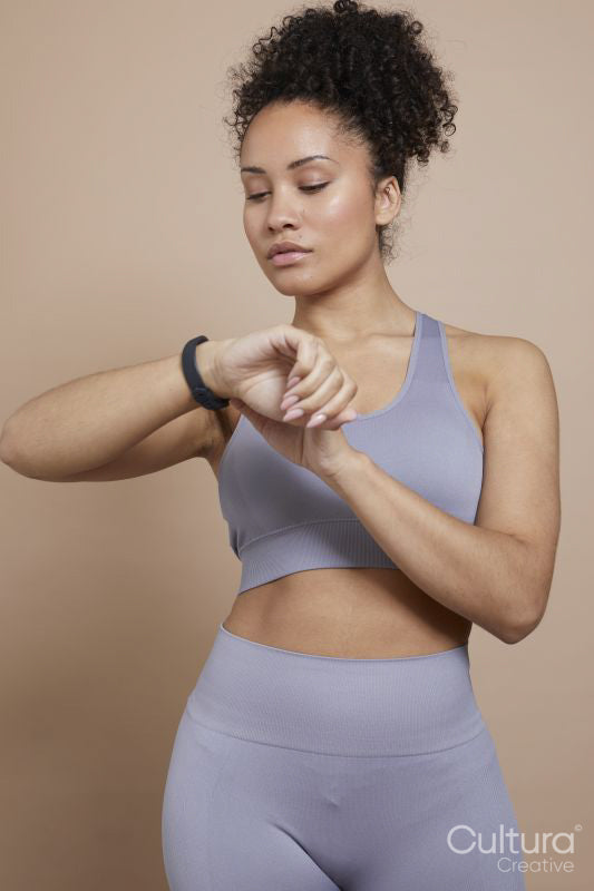 Studio portrait of athletic woman checking smart watch