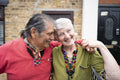 Portrait of smiling senior couple in front of house