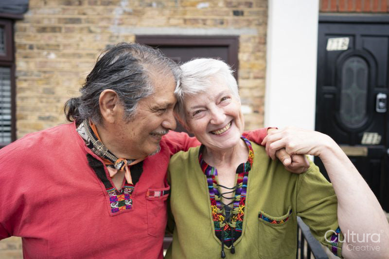 Portrait of smiling senior couple in front of house