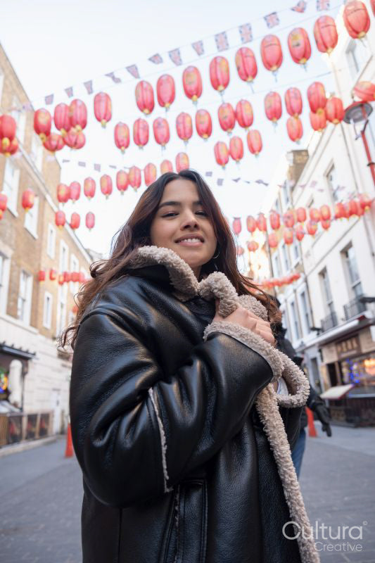 Portrait of young woman with traditional lanterns in background in Chinatown