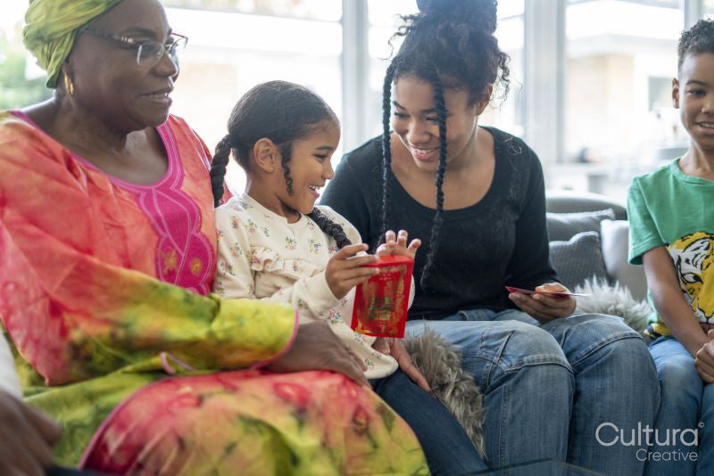 Family gathered in living room, sharing red envelopes