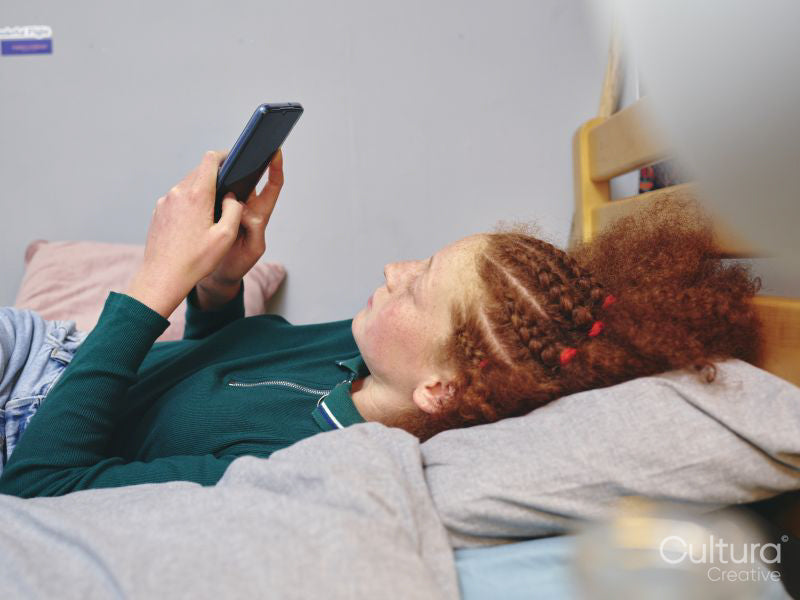 Girl lying on bed and using smart phone