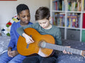 Boy friends playing guitar at home