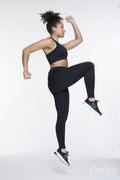 Studio shot of athletic woman in spots clothing exercising