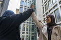 Two women wearing hijabs doing high-five