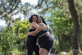 Smiling couple in sports clothing hugging in park