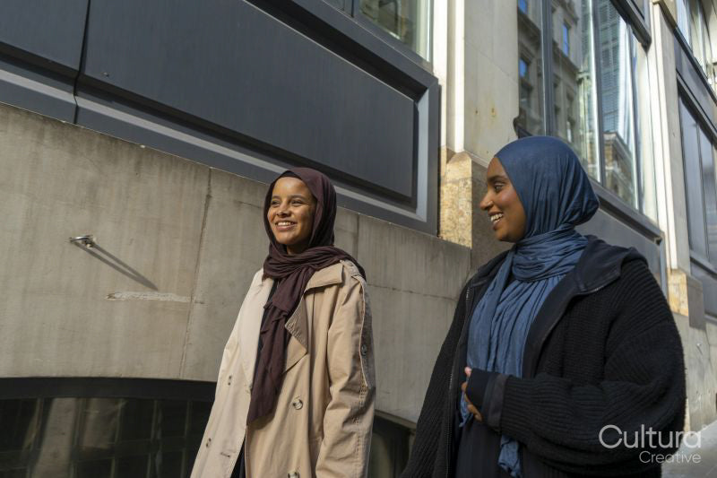Two young women walking in street