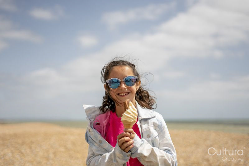 Portrait of smiling girl eating ice cream on beach