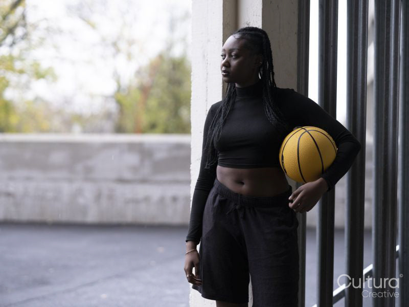 Young woman holding basketball outdoors