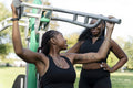Young female friends working out in outdoor gym