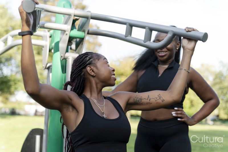 Young female friends working out in outdoor gym