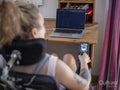 Woman in electric wheelchair working on laptop