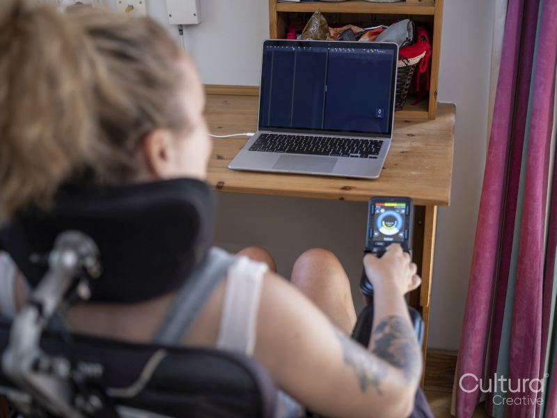 Woman in electric wheelchair working on laptop