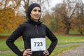 Portrait of woman in black sports clothing and hijab with race number